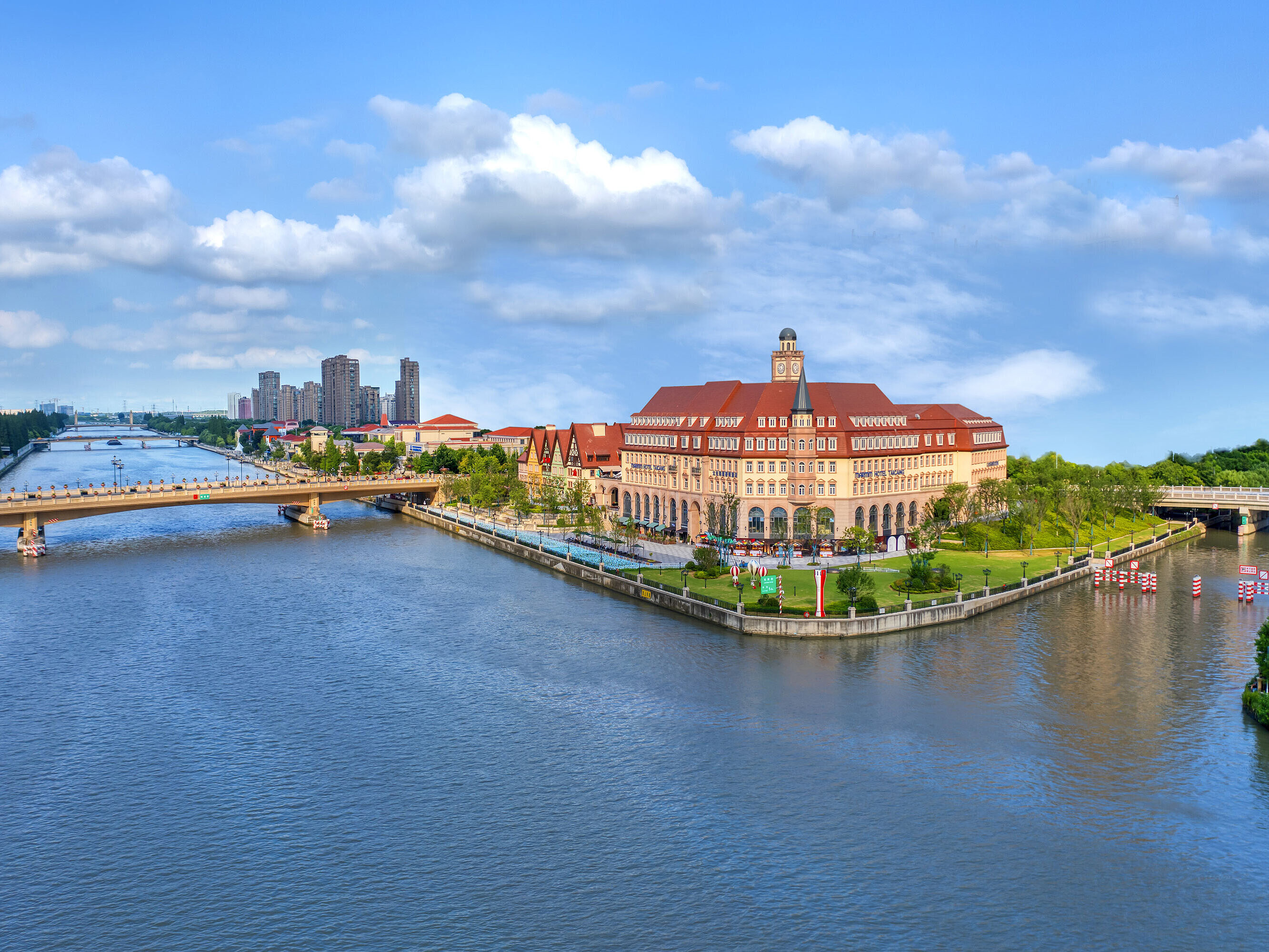 Aerial view of Maritim Hotel Taicang on a riverside peninsula with bridges and greenery