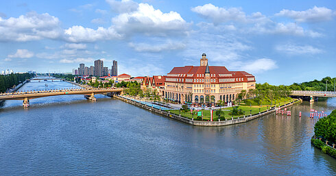 Aerial view of Maritim Hotel Taicang on a riverside peninsula with bridges and greenery