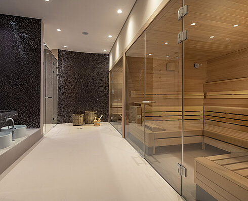 Modern spa area with glass sauna, cozy seating, and a stylish atmosphere at Maritim Hotel Ingolstadt.