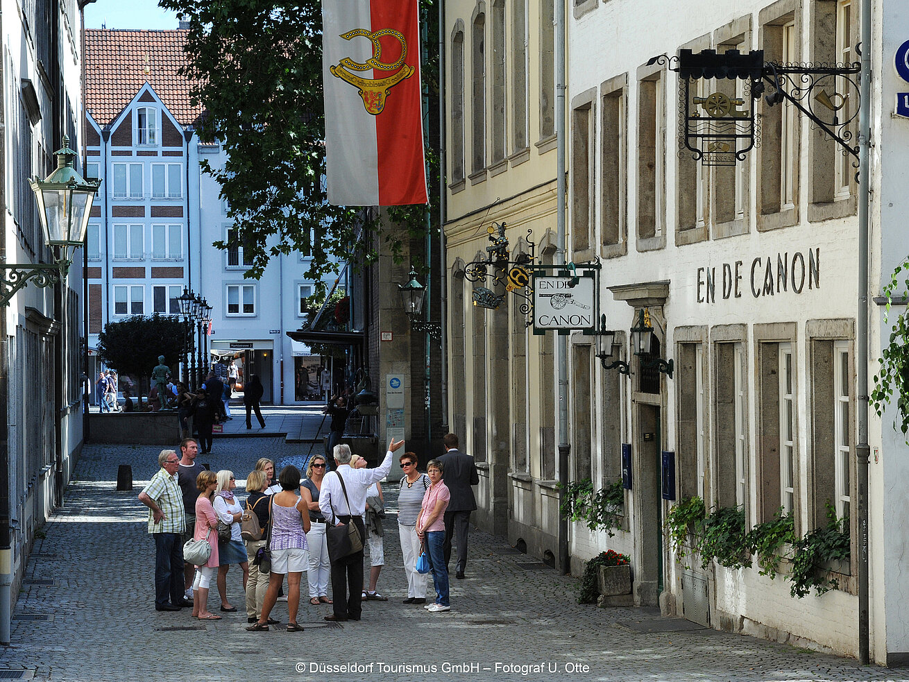 Guided city tour through Düsseldorf’s old town with historic buildings and visitors in a narrow street