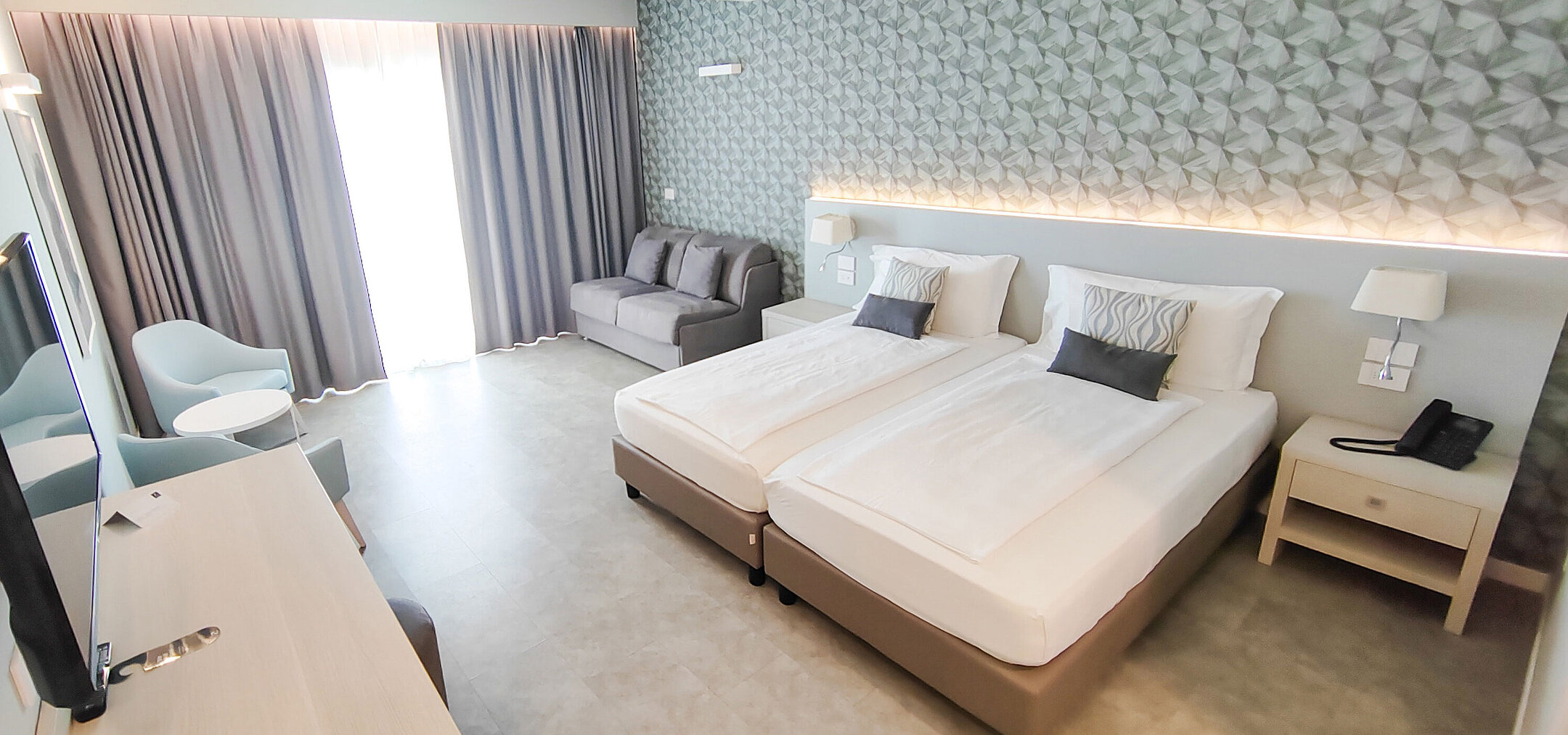 Spacious room at Maritim Resort Calabria with twin bed, sofa, desk and bright design