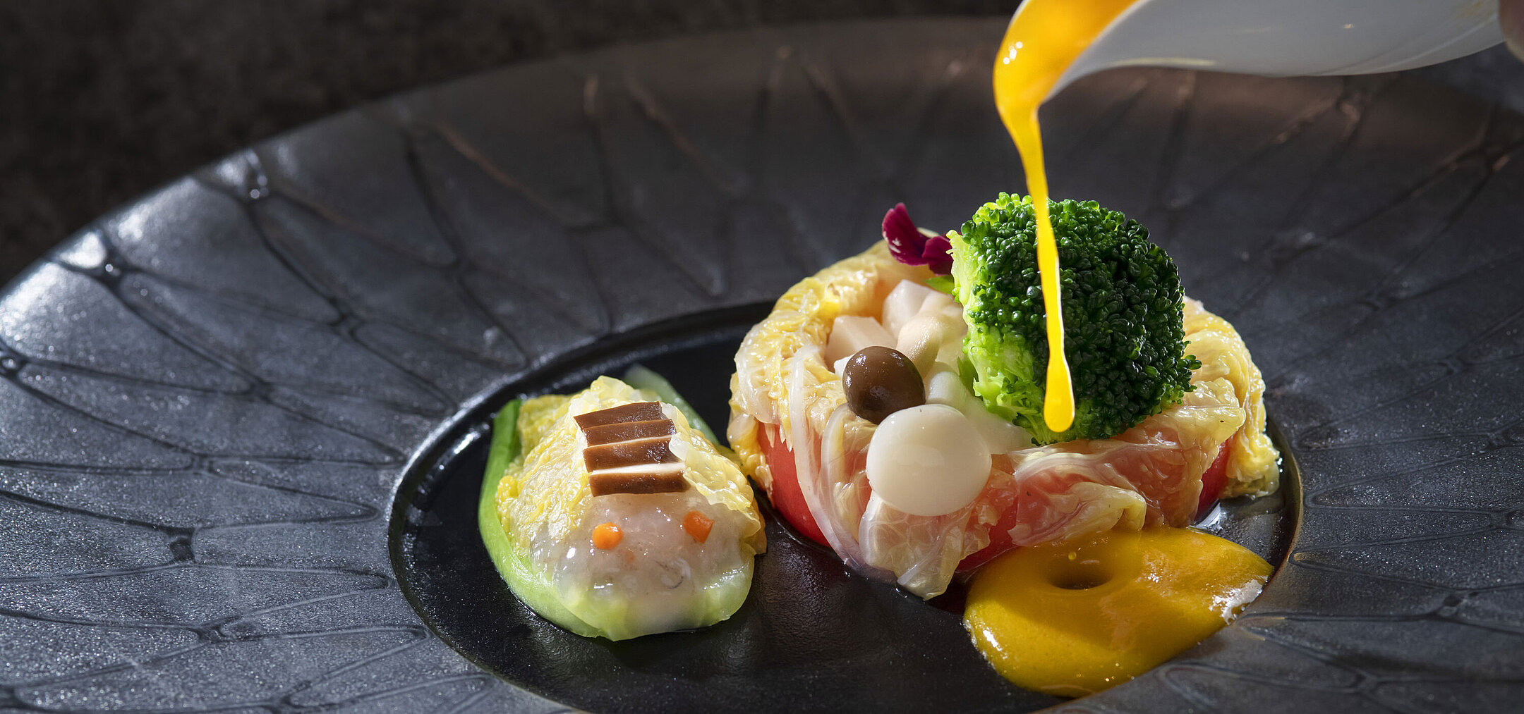 Finely presented gourmet dish with vegetables, meat and sauce served fresh at the table