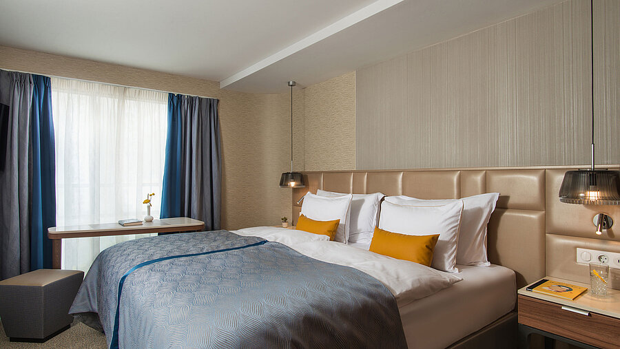 Bright double room at Maritim Hotel Amelia with blue bedspread, modern lighting and cosy atmosphere