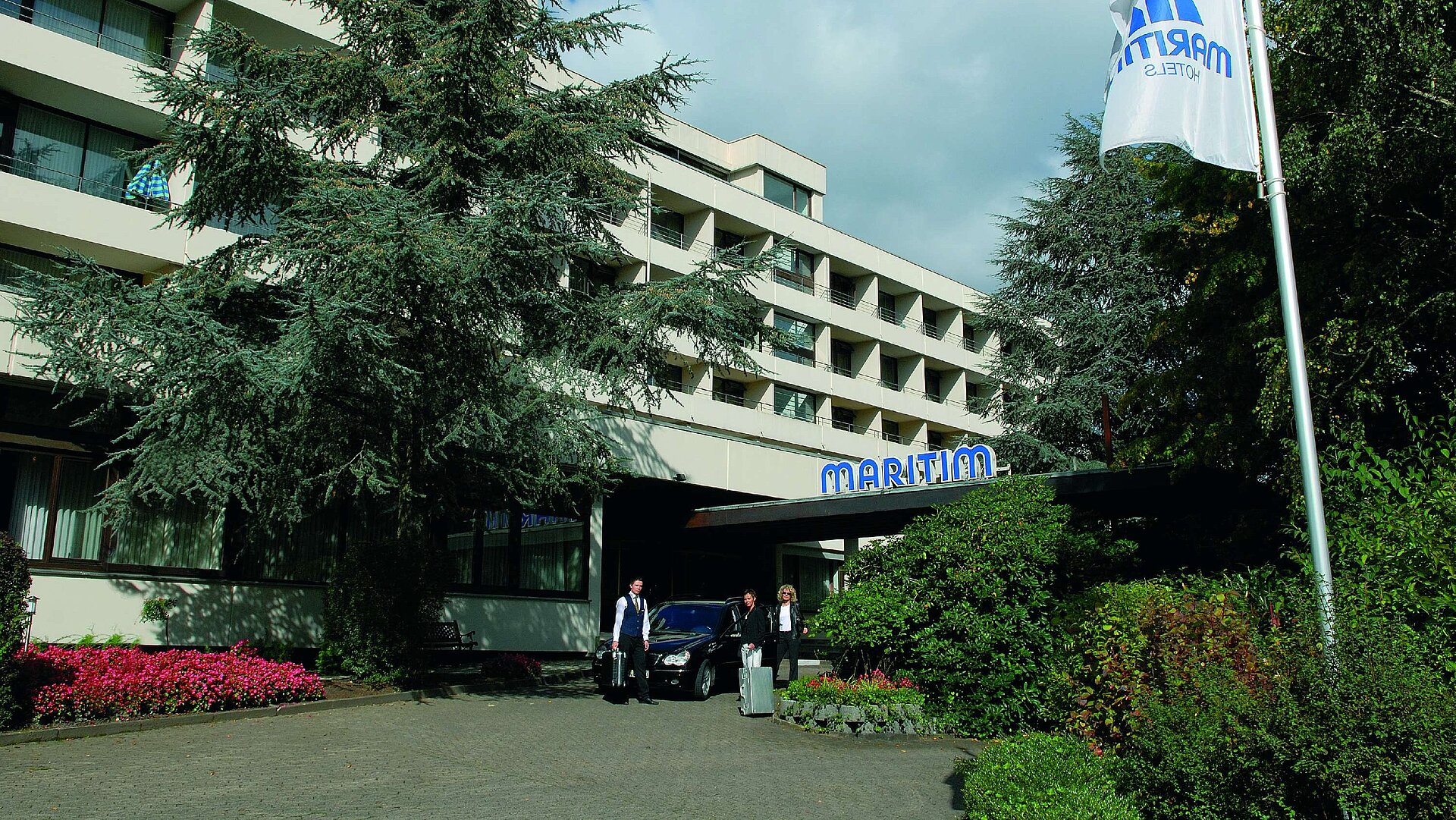 Guests arrive at Maritim Hotel Bad Salzuflen surrounded by trees and landscaped greenery