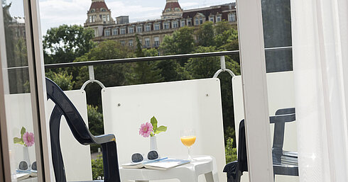 Balcony view with table, flowers, juice and a view of Bad Wildungen at Maritim Hotel
