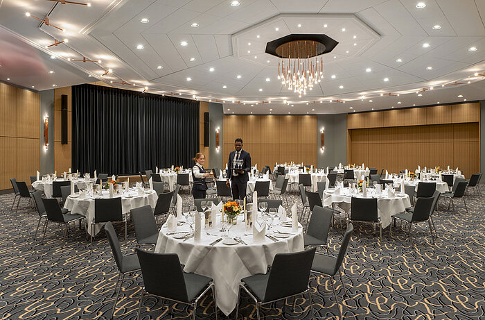 Large Barbarossa Banquet Hall at the Maritim Hotel Würzburg with round tables and a stylish ambience.