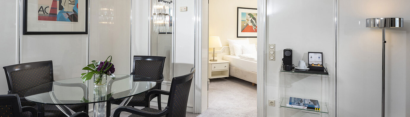 Bright Executive Suite at Maritim Hotel Frankfurt with stylish dining area, glass table, and direct access to the bedroom.