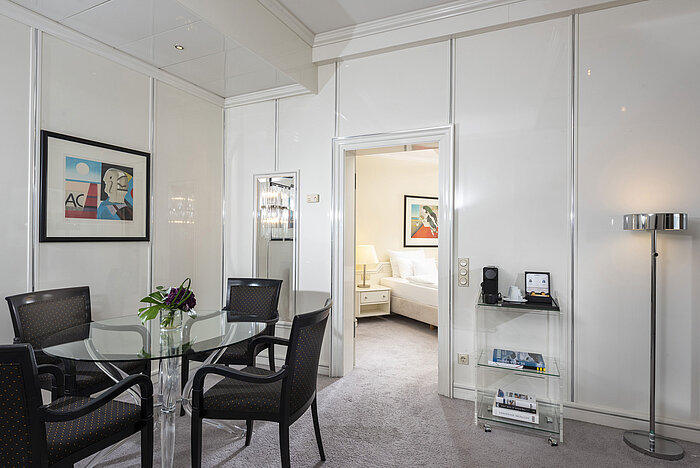 Bright Executive Suite at Maritim Hotel Frankfurt with stylish dining area, glass table, and direct access to the bedroom.