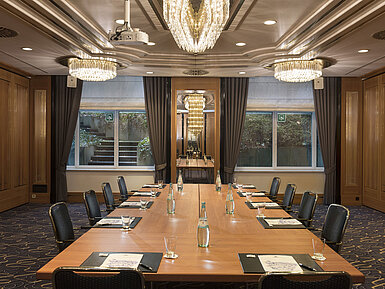 Meeting room with large conference table, chairs and chandeliers at Maritim Hotel Stuttgart