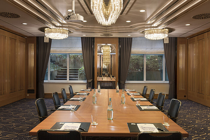 Meeting room with large conference table, chairs and chandeliers at Maritim Hotel Stuttgart