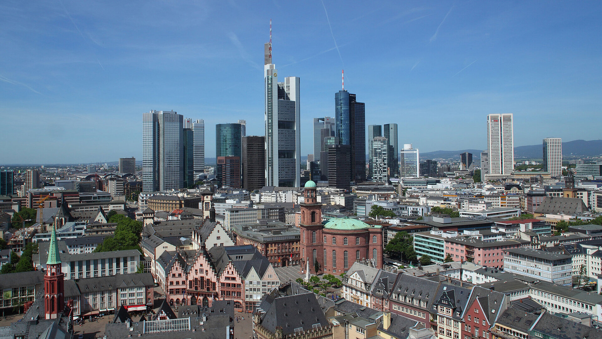 View of Frankfurt's skyline with the Römer and St. Paul's Church in the foreground on a clear day.
