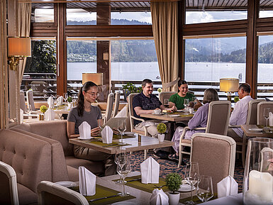 Guests enjoying a meal in the elegant restaurant with panoramic view of Lake Titisee
