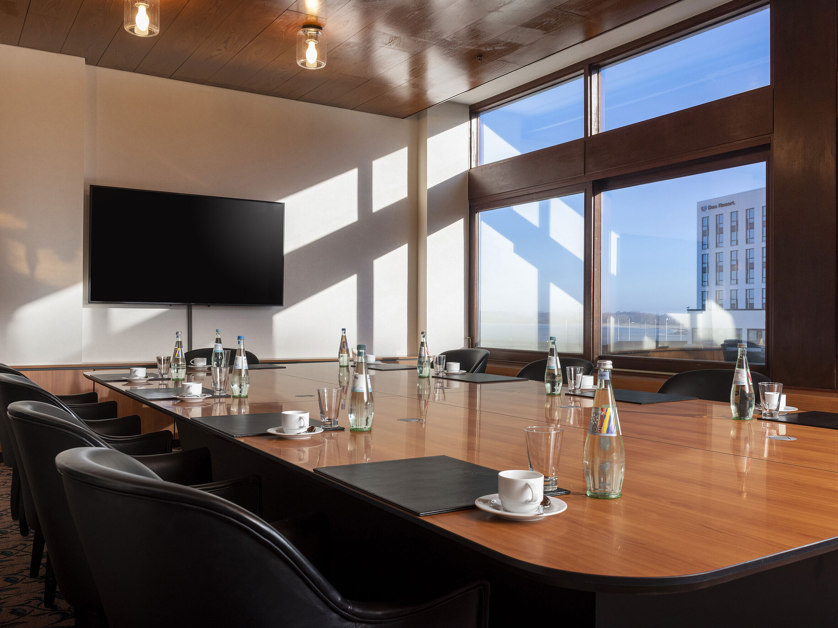 Bright meeting room at Maritim Hotel Travemünde with screen and window view