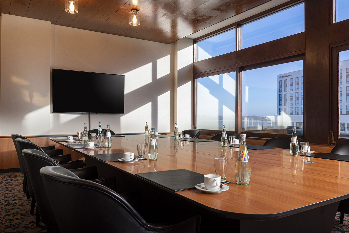 Bright meeting room at Maritim Hotel Travemünde with screen and window view