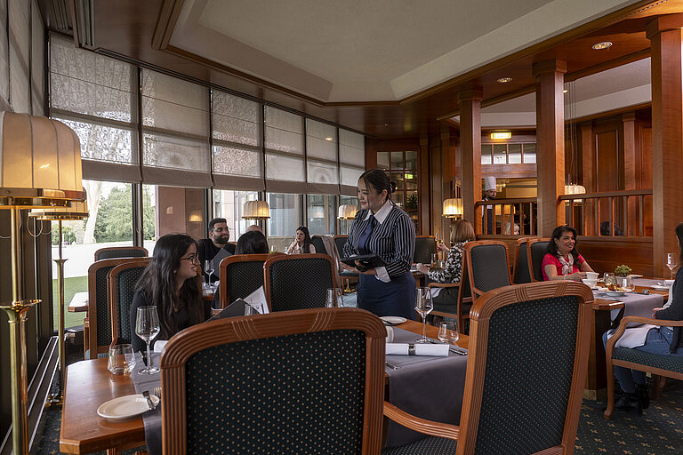 Guests dine in the stylish restaurant of Maritim Hotel Bad Homburg, while friendly staff provides excellent service.