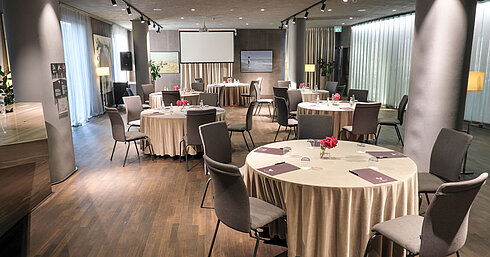 Flexible event space at Maritim Hotel Plaza Tirana with round tables, daylight and flowers on each table