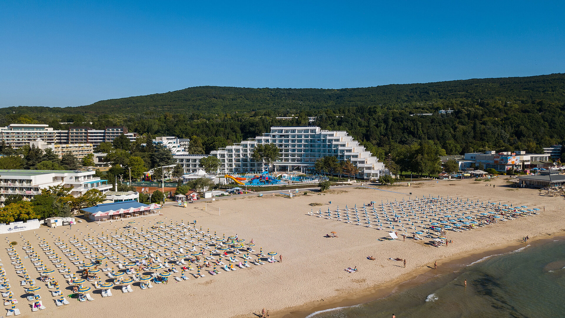 Spacious beach area with the Maritim Hotel, sun umbrellas and views of green hills for a perfect summer holiday