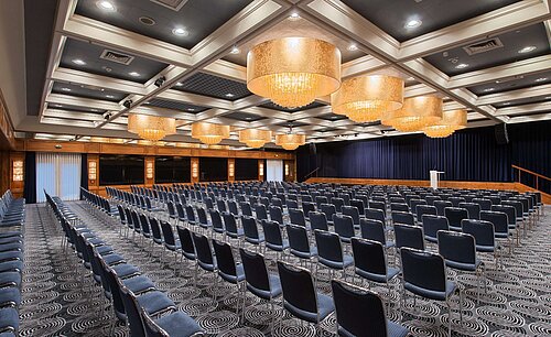 Elegant hall at Maritim Hotel Darmstadt featuring row seating, stunning chandeliers, and perfect setup for events.