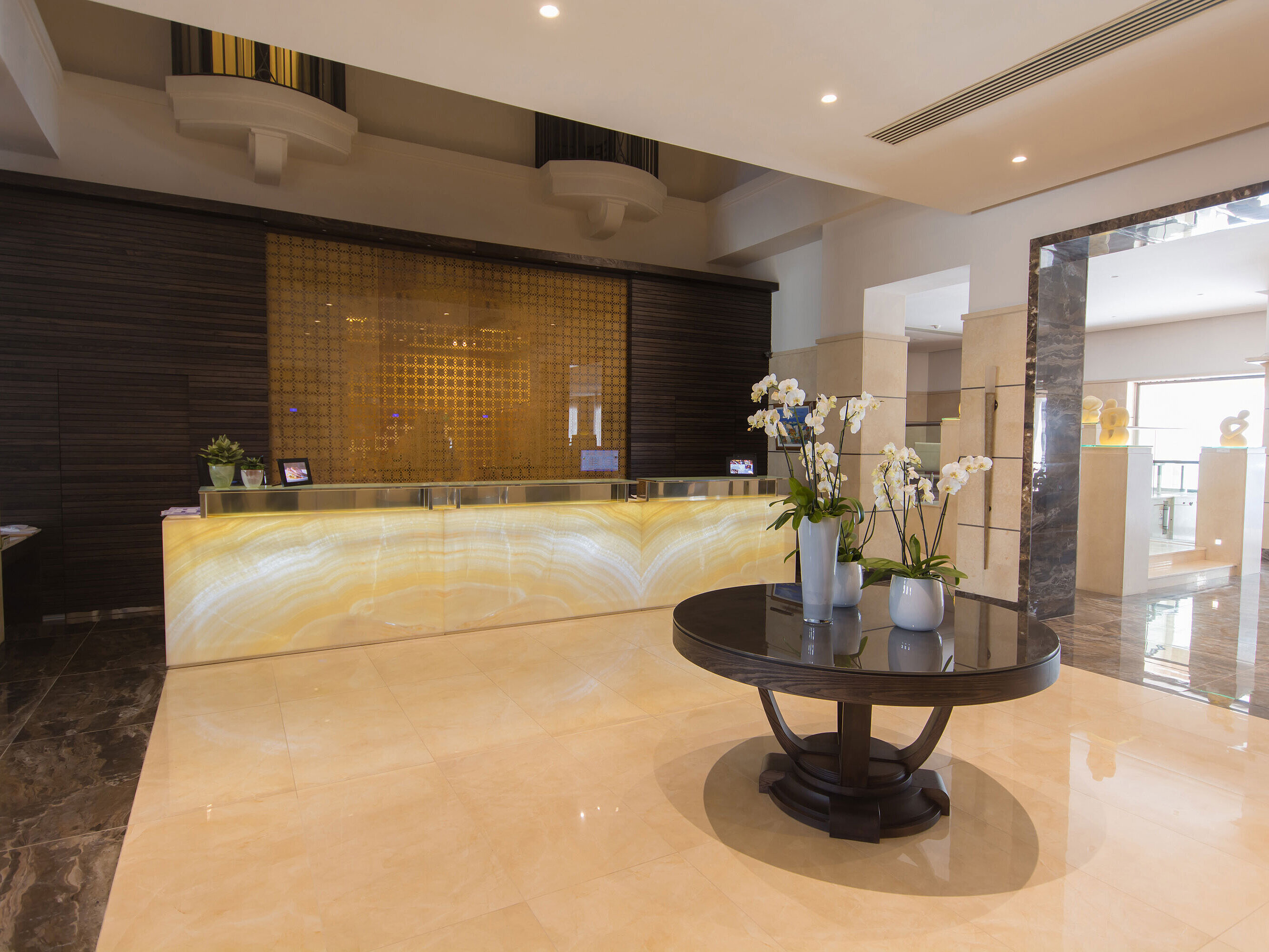 Modern hotel reception with illuminated desk, orchids and elegant design