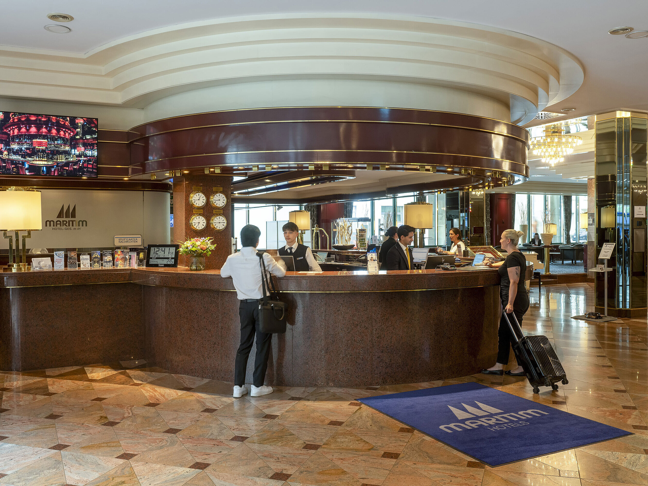 Guests checking in at the stylish reception desk of the Maritim Hotel Stuttgart.