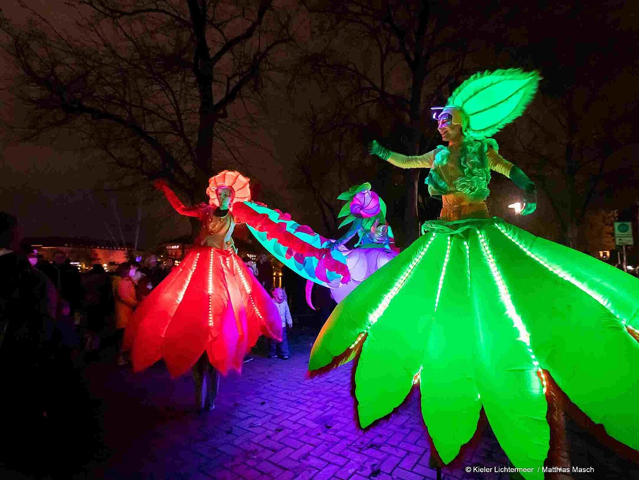 Kieler Lichtermeer © Matthias Masch Illuminated stilt walkers in colourful costumes at night light festival