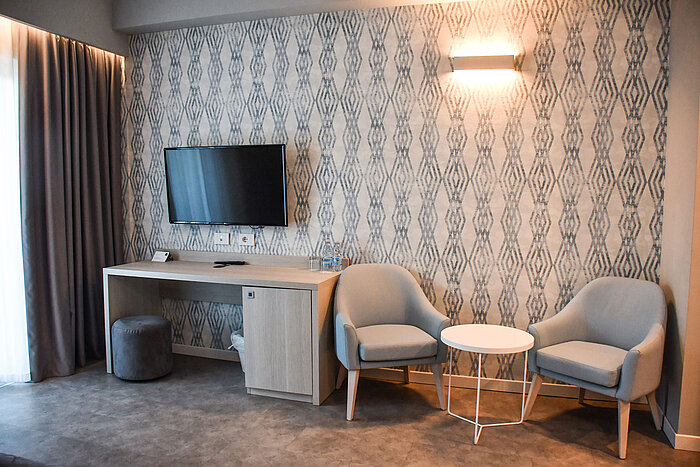 Modern seating area with TV and desk in the room at Maritim Resort Calabria