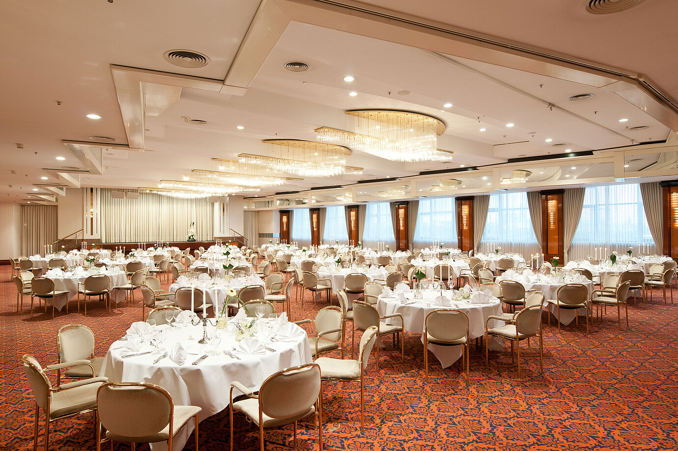 Elegant banquet hall with chandeliers, festively set tables, and a stylish ambiance at Maritim Hotel Magdeburg.