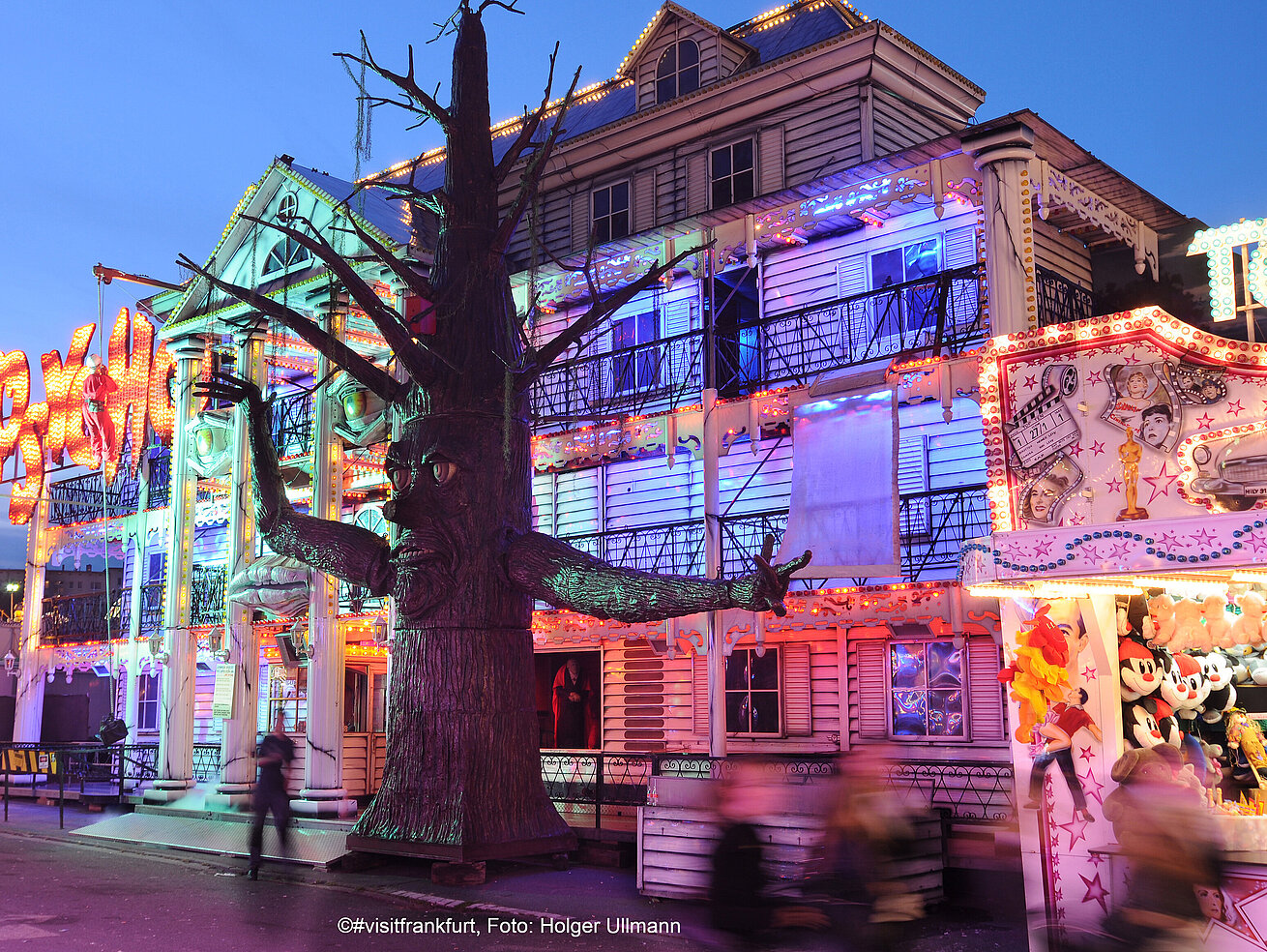 Illuminated haunted house ride at a fair with decorated facade