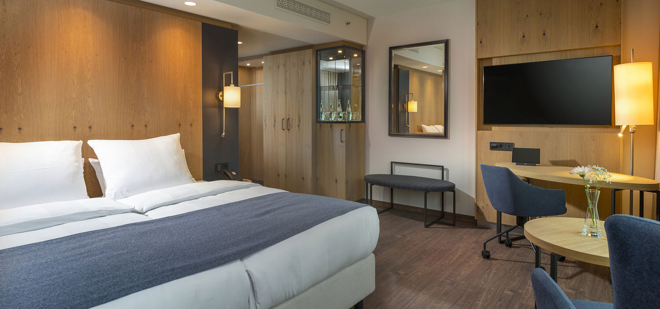 Modern double room at Maritim Hotel Ingolstadt with stylish decor and a desk.