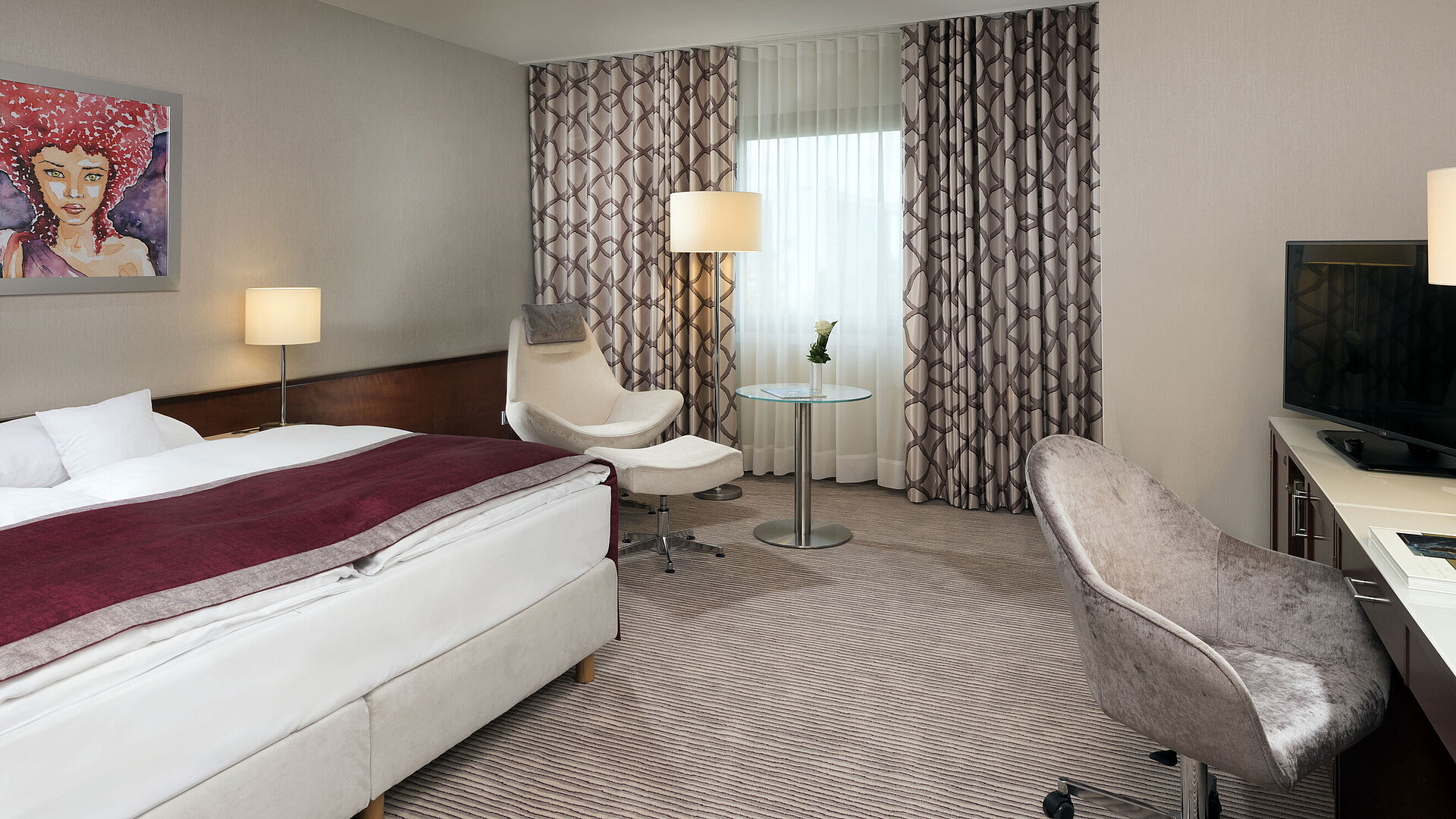 Comfort room at Maritim Hotel Bonn with cozy bed, chairs, desk, and modern curtains.