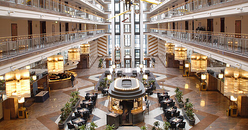 Large atrium with multi-level architecture, lounge area, and modern interior at Maritim Hotel Hannover.