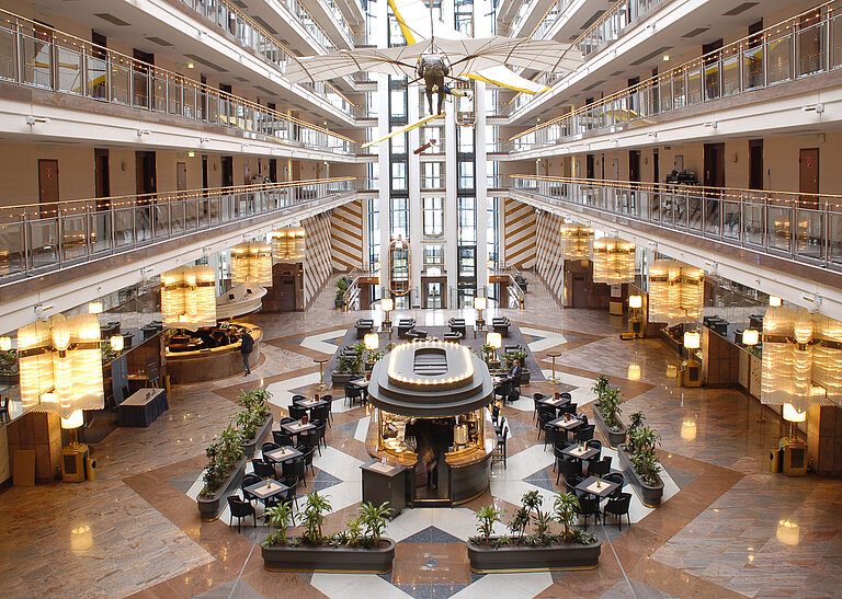 Large atrium with multi-level architecture, lounge area, and modern interior at Maritim Hotel Hannover.