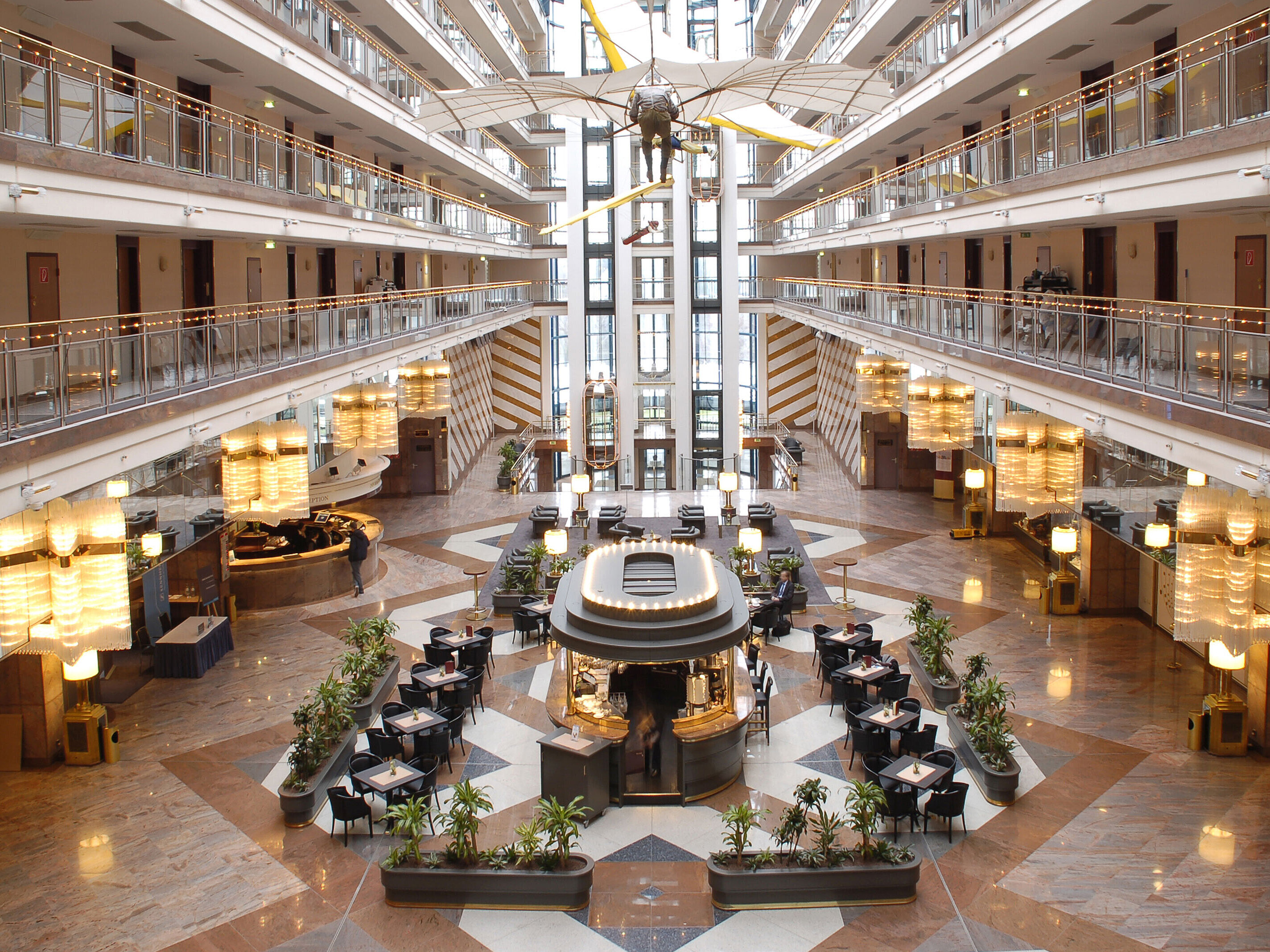 Large atrium with multi-level architecture, lounge area, and modern interior at Maritim Hotel Hannover.