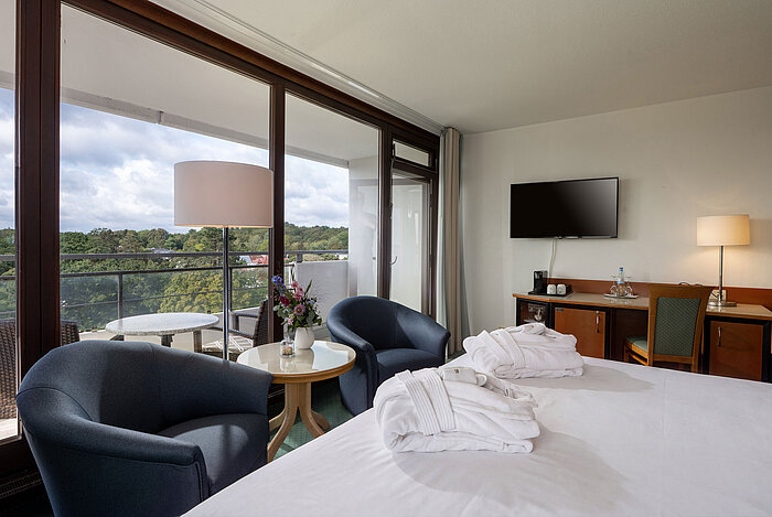 SuperiorPlus Room facing the park with double bed, seating area, balcony and views of the greenery
