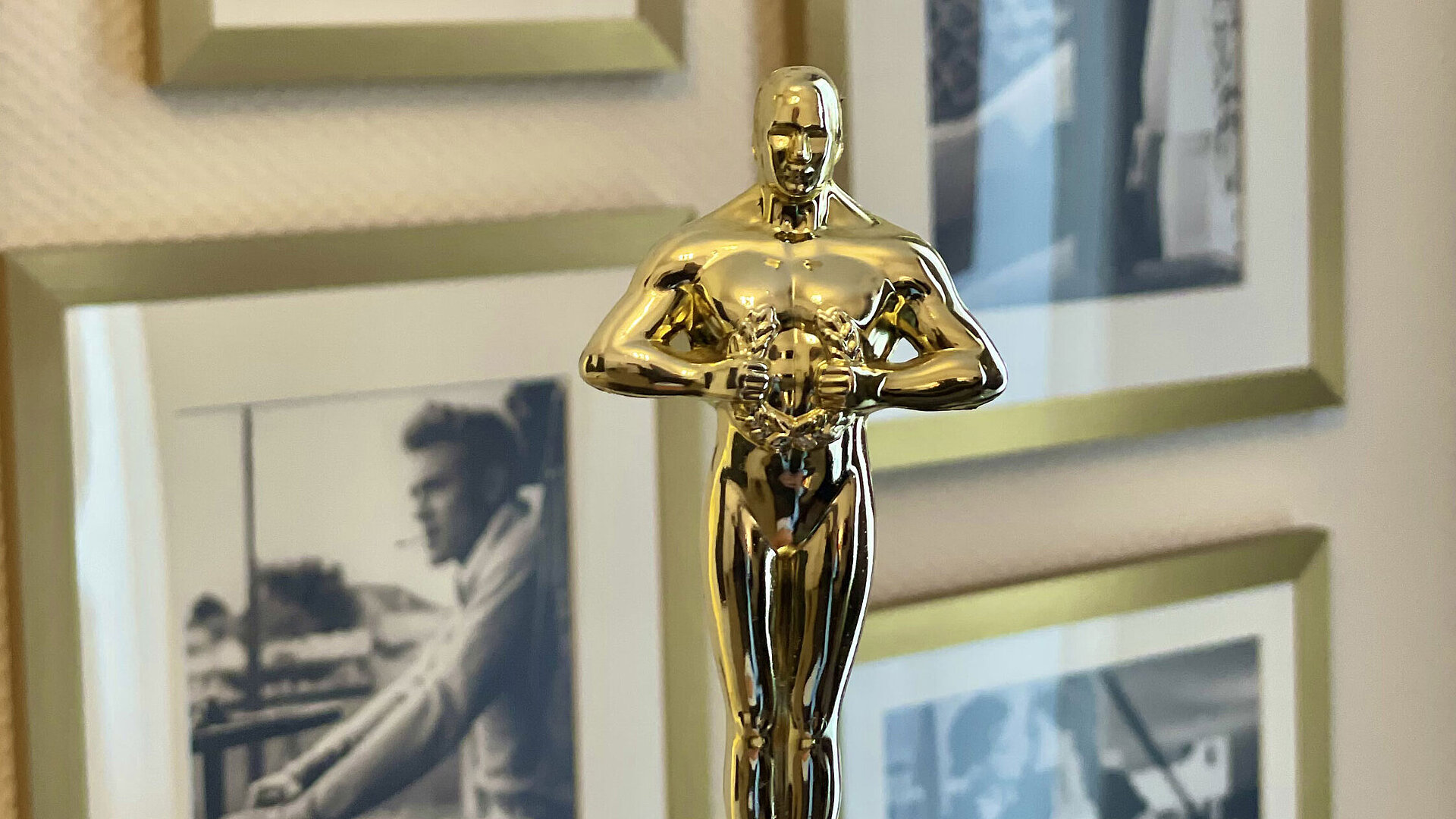 Golden film award statue as decoration in front of framed black and white photographs