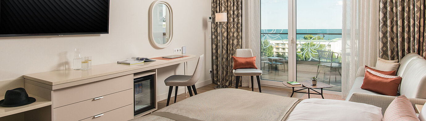 Bright room at Maritim Hotel Amelia with desk, seating area and balcony view of the sea