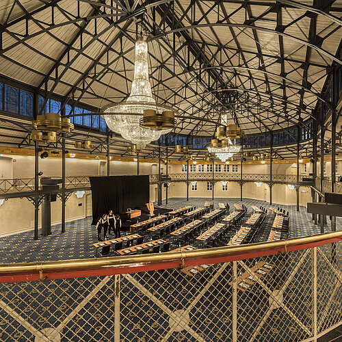 Historic riding hall with stage, chandeliers and seating rows at Maritim Hotel Stuttgart