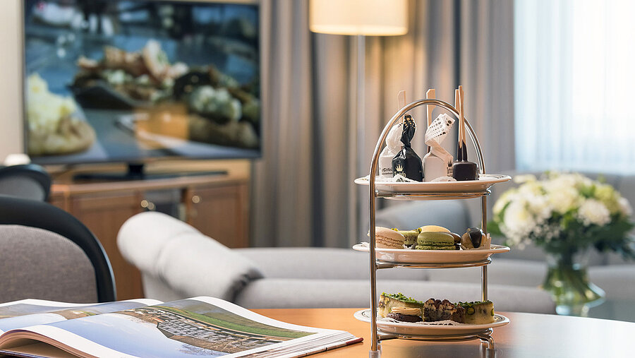 Elegant lounge with a tiered tray of sweet treats in the Junior Suite at Maritim Hotel Hannover.