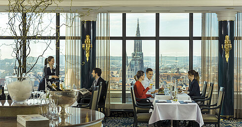 Guests enjoying a meal with a view of Ulm Minster at the panorama restaurant of Maritim Hotel Ulm
