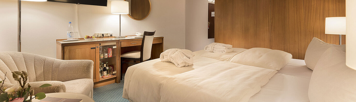 Classic room at Maritim Seehotel Timmendorfer Strand with twin beds, minibar, desk, TV, and seating area.