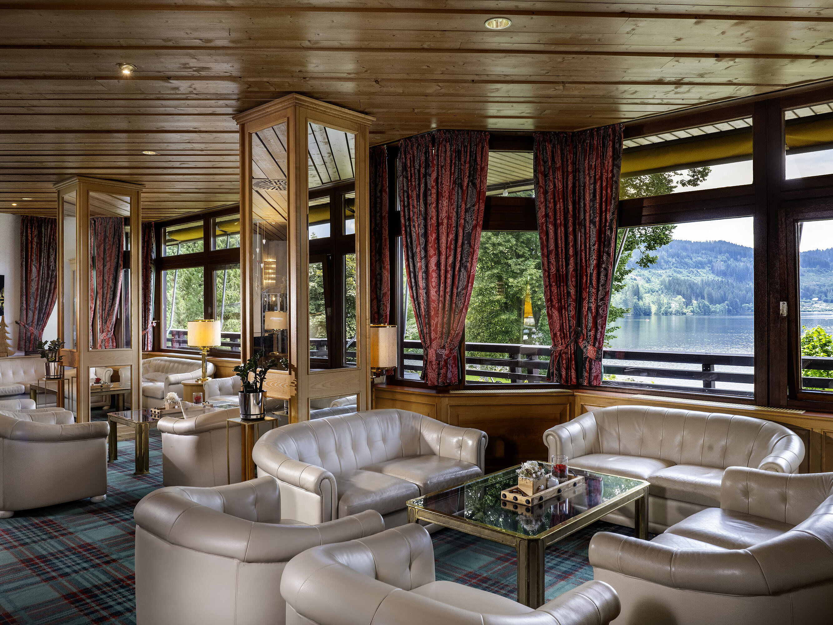 Bright hotel lobby with leather armchairs and lake view at Maritim Hotel Titisee