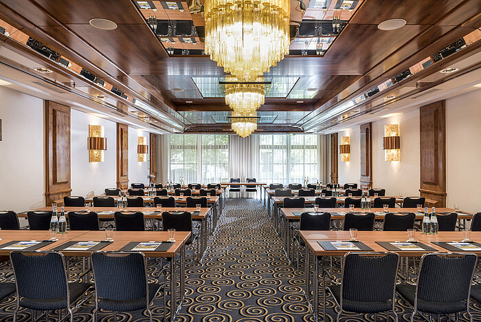 Stylish meeting room with large chandeliers, natural light, and modern seating at Maritim Hotel Königswinter.