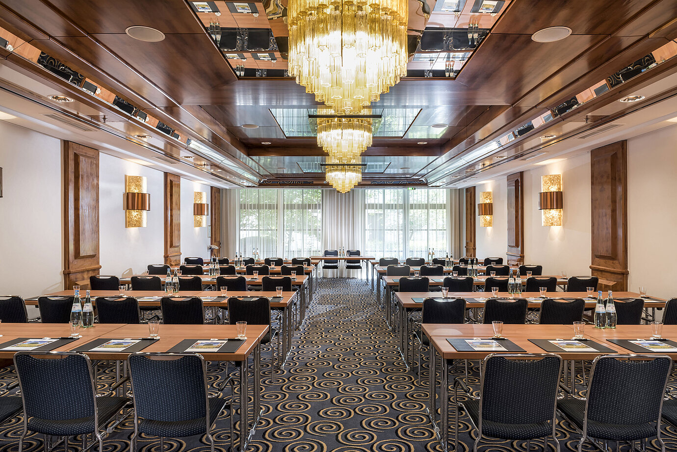 Stylish meeting room with large chandeliers, natural light, and modern seating at Maritim Hotel Königswinter.