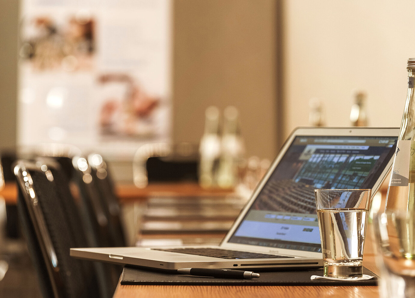 Laptop, pen and glass of water on table in the conference room at the Maritim Hotel Munich