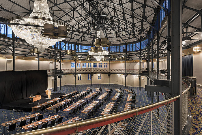 Historic riding hall with stage, chandeliers and seating rows at Maritim Hotel Stuttgart