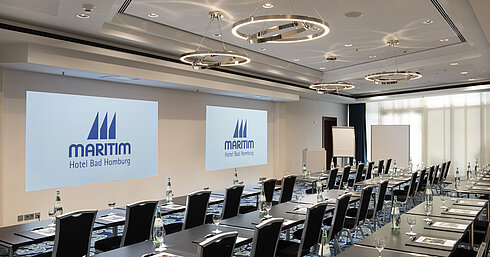Modern conference room at Maritim Hotel Bad Homburg with seating and projection.
