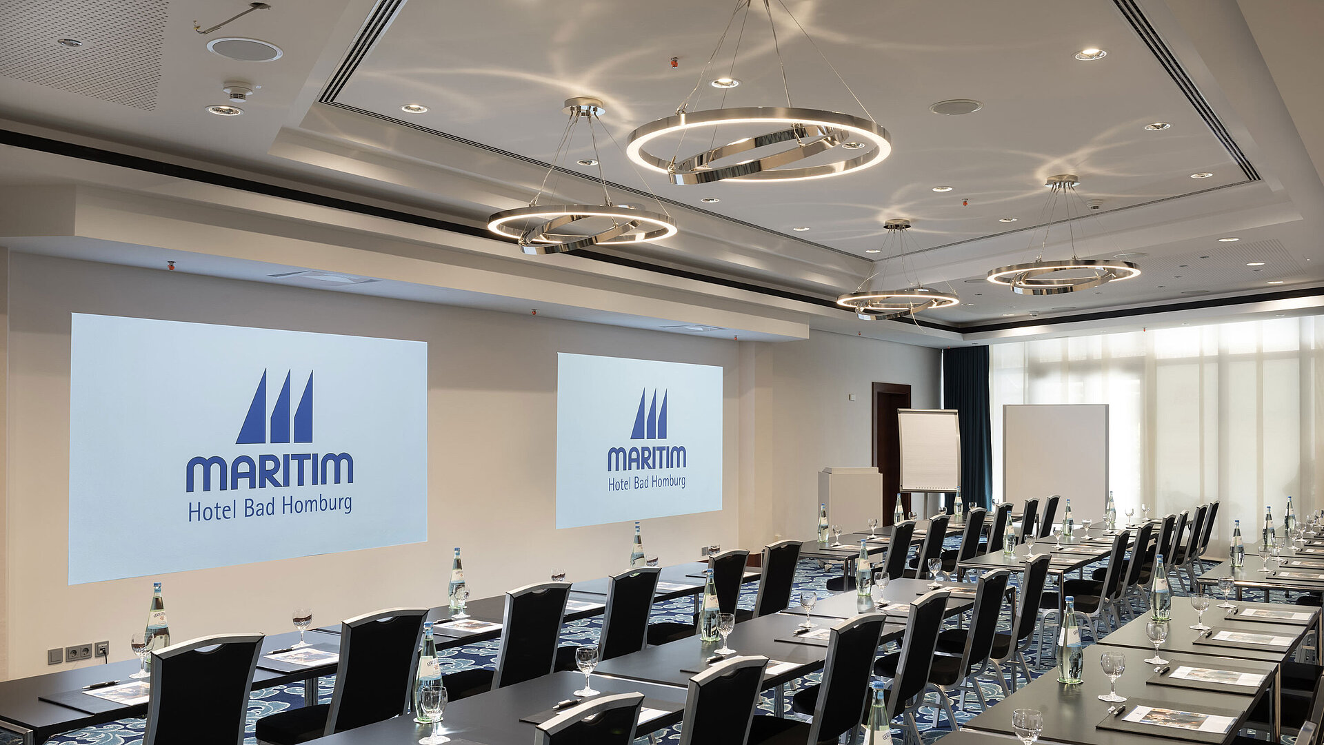 Modern conference room at Maritim Hotel Bad Homburg with seating and projection.