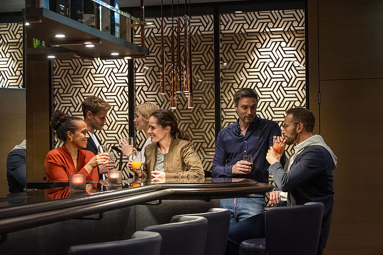 Guests enjoy drinks and lively conversations in the stylish bar at Maritim Hotel Ingolstadt.