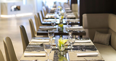 Row of set tables with glasses and flowers in the elegant restaurant of Maritim Hotel Plaza Tirana
