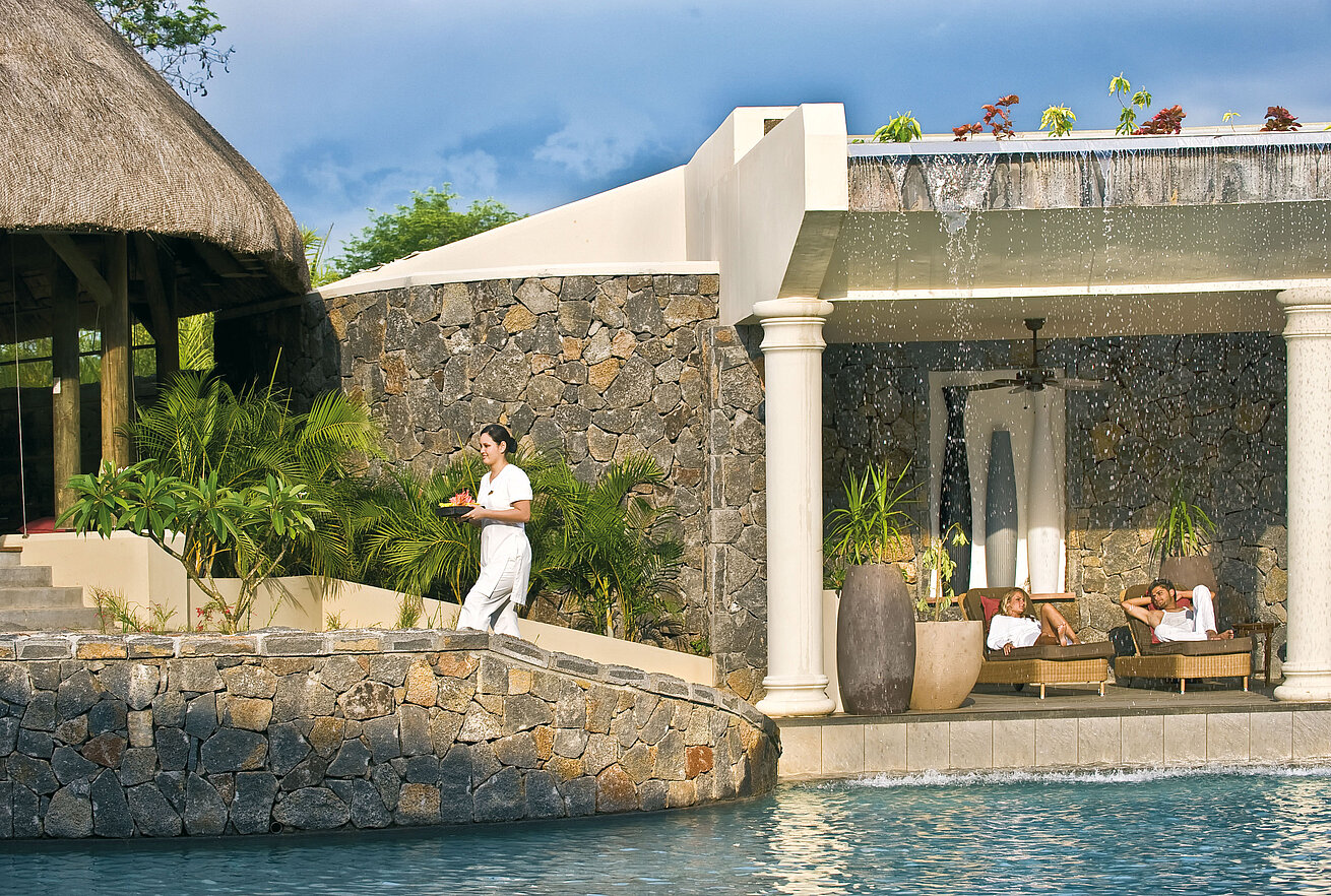 Outdoor spa area with pool, waterfall, relaxation loungers and personal service